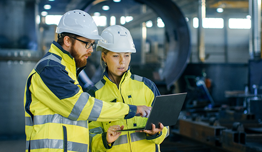 Two people in a manufacturing plant